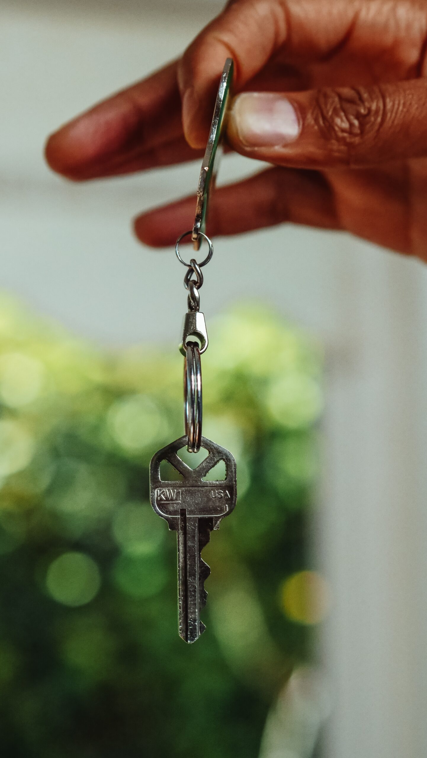 person holding keychain of house keys
