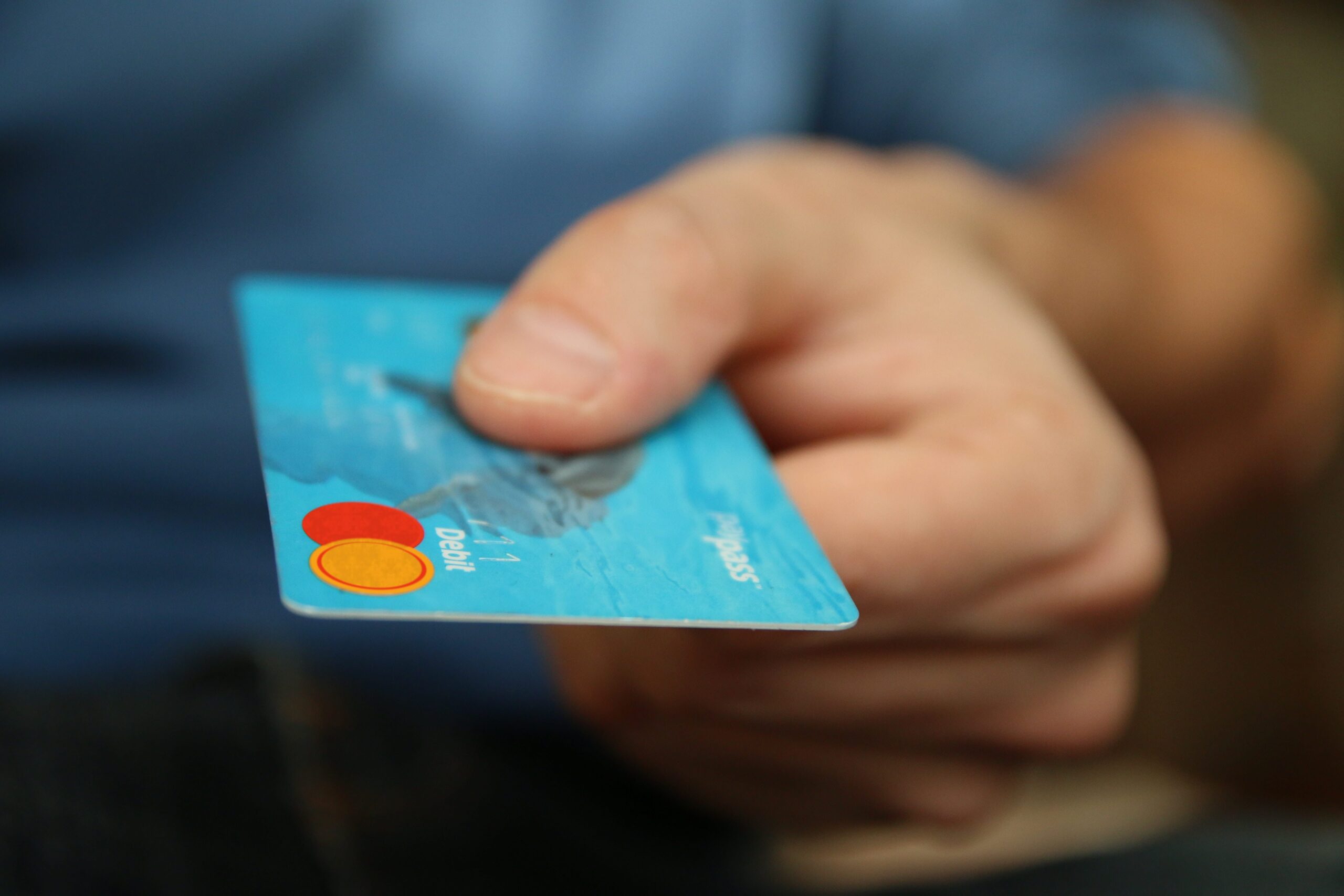 man holding credit card to use to pay for things and increase his debt