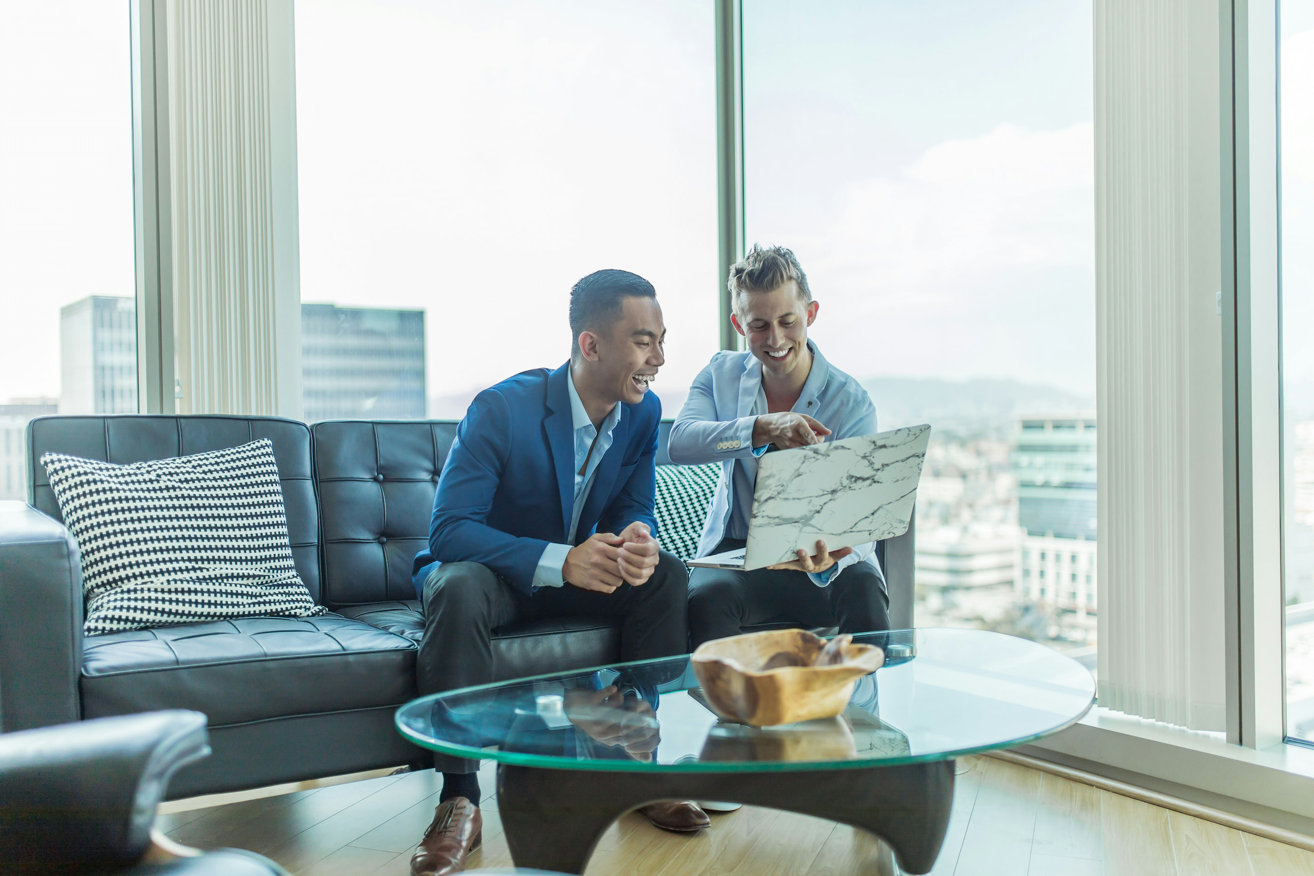 austin-distel-jpHw8ndwJ_Q-unsplash (2) Two professionals collaborating on a laptop in a modern office, representing the partnership between Realtors and mortgage brokers to close more deals