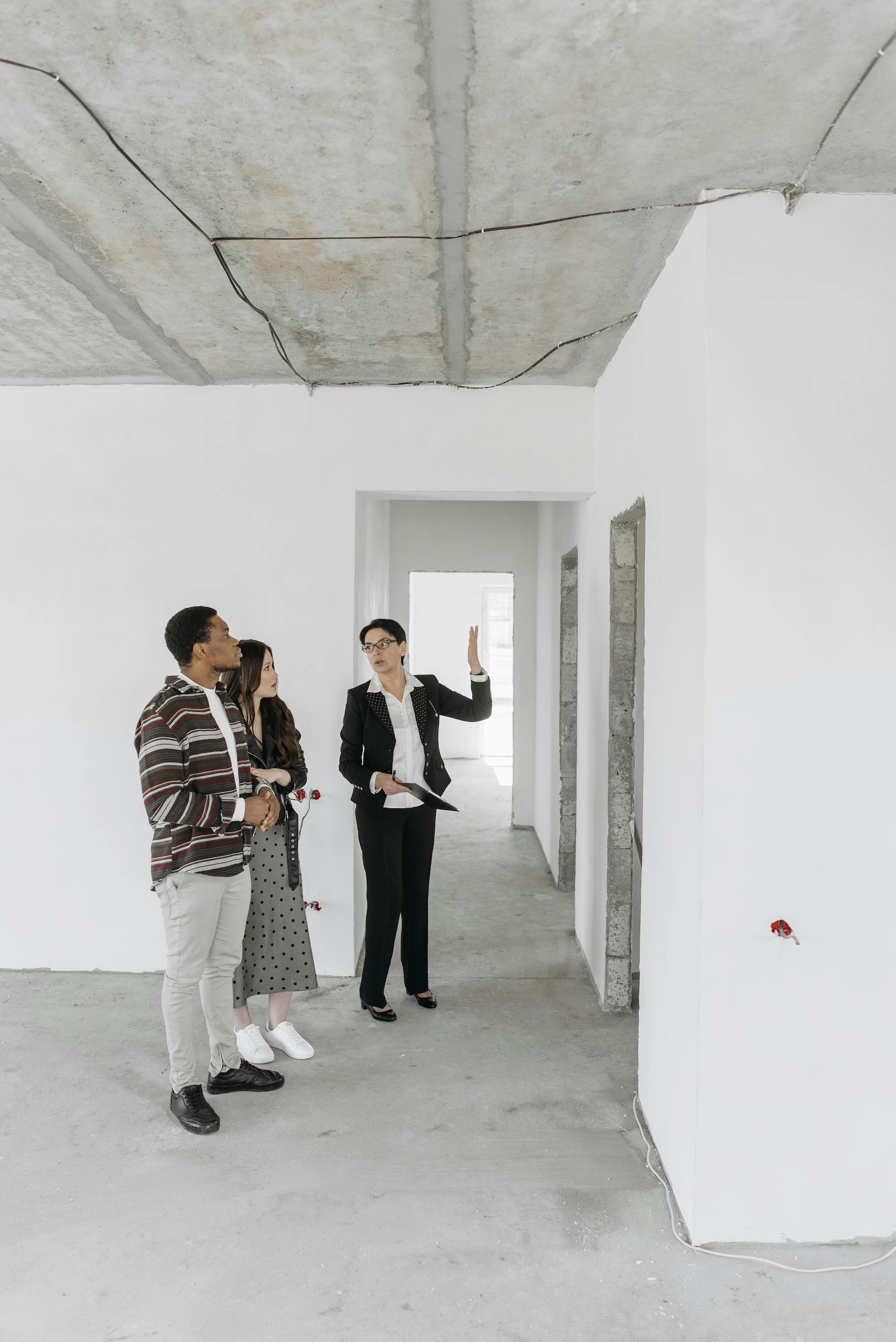 pexels-pavel-danilyuk-7937368 (2) A Realtor showing a property to prospective buyers in an unfinished building, highlighting professional real estate services