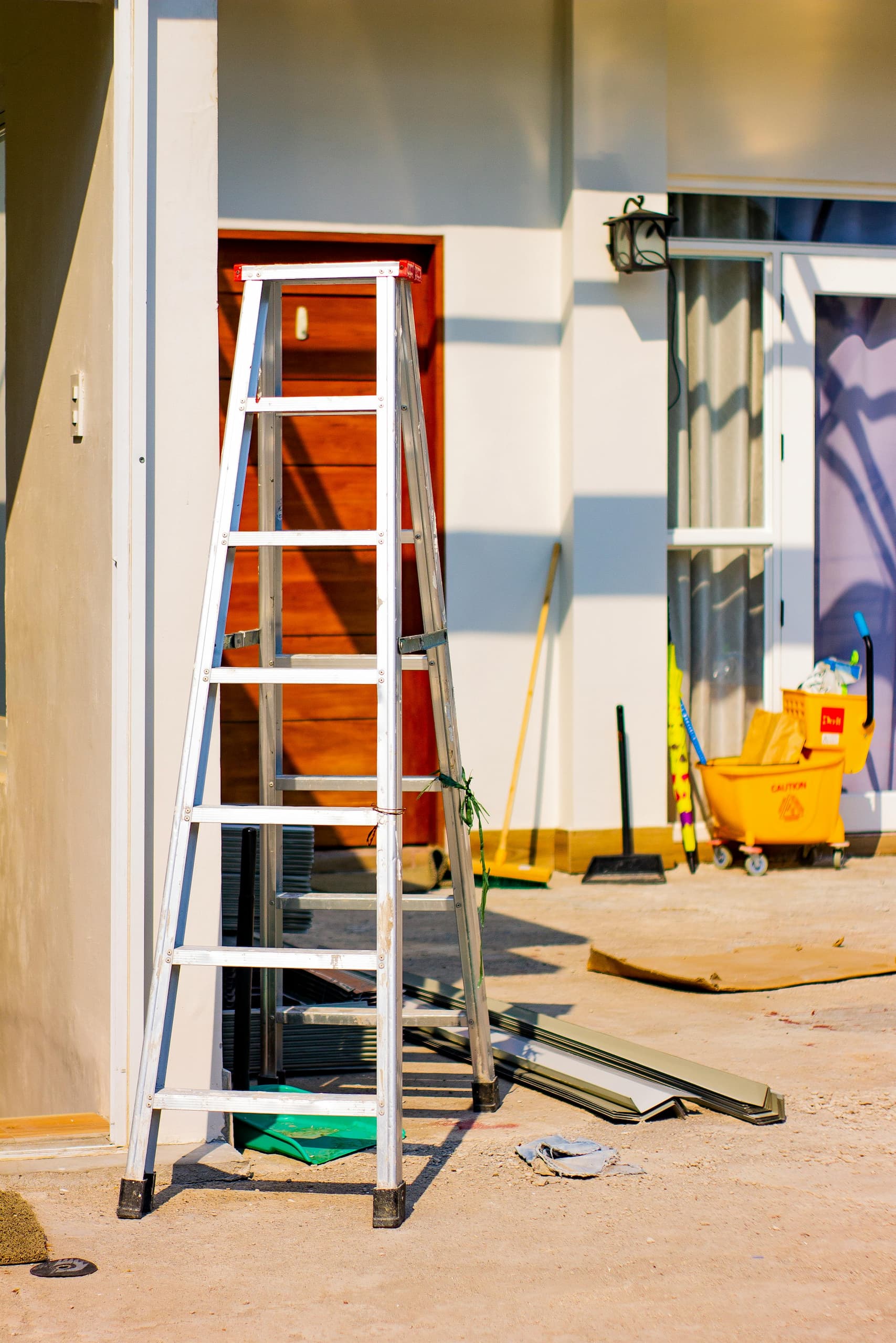 pexels-ian-panelo-4567378 (1) A ladder and renovation tools outside a home under construction, representing a fixer-upper property and real estate investment potential through renovation.
