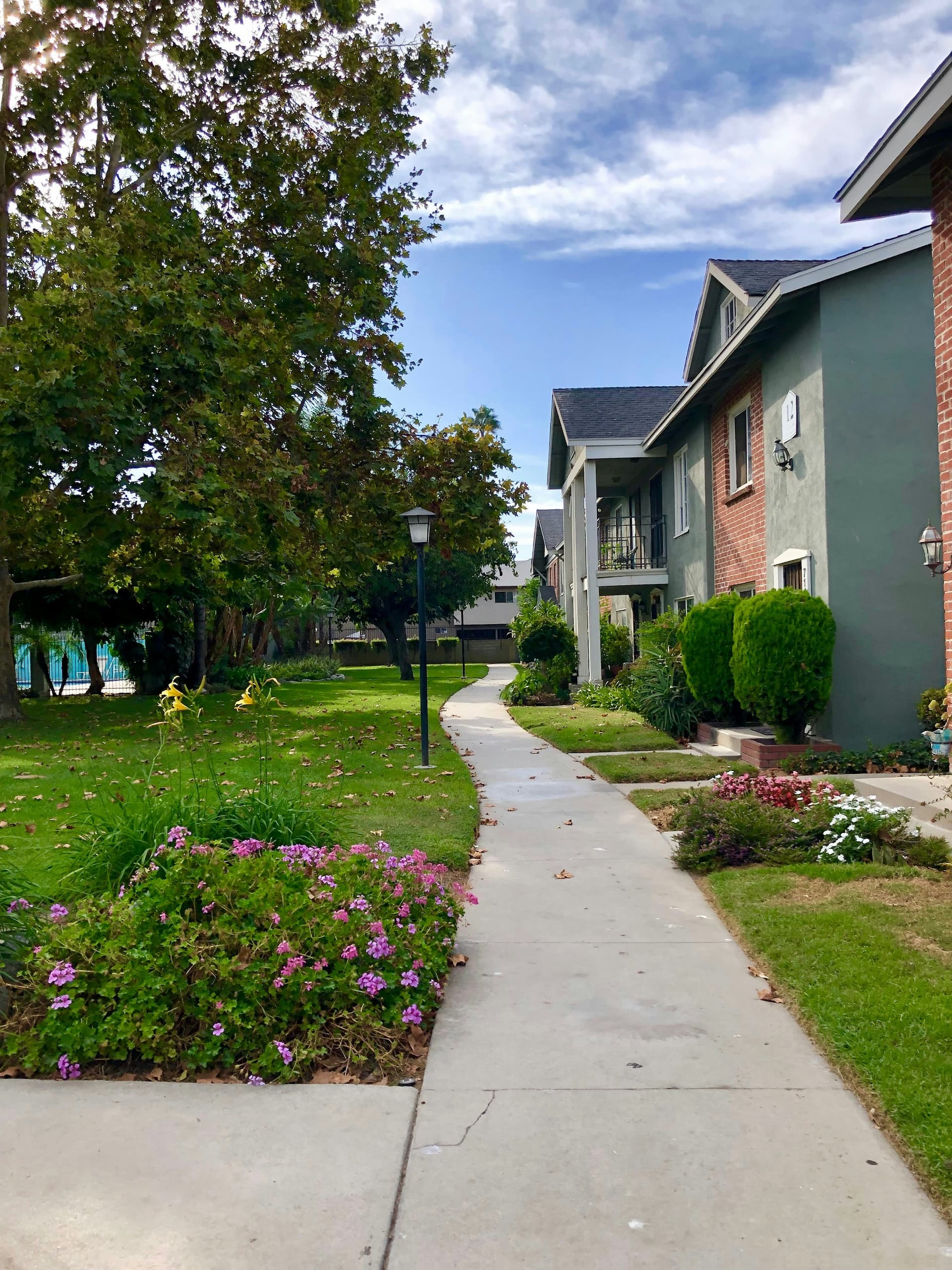 shona-corsten-WtF2LGnC72o-unsplash (1) A well-maintained HOA community with landscaped walkways, green spaces, and townhomes, showcasing the benefits of buying a home in a homeowners association.